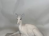 a statue of a white deer sitting on top of a table