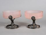 une paire de verres à pied en verre rose posés sur un socle en métal