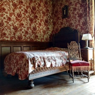 un lit et une chaise dans une pièce dont l'un des murs est tapissé