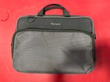 a gray bag with a black handle sitting on top of a red surface
