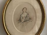 une vieille photo d'une femme assise sur une chaise à côté d'un vase