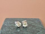 une paire de boucles d'oreilles en diamant posée sur un écrin en marbre vert