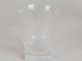 a clear glass vase with a curved base on a white surface