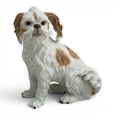 a figurine of a dog sitting on a white surface