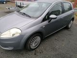 a small grey car parked in a parking lot