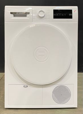 une photo d'un sèche-linge blanc posé par terre