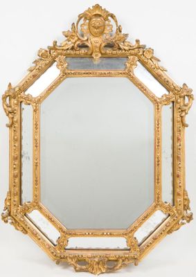 an ornately carved mirror with a gold frame on a white background