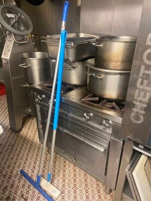 pots and pans are sitting on the floor in a commercial kitchen