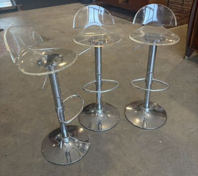 three clear stools sitting on top of a floor next to each other