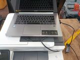a laptop computer sitting on top of a printer on a table