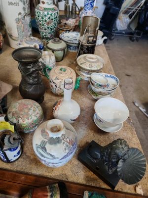 une table sur laquelle sont disposés de nombreux vases et assiettes de toutes sortes
