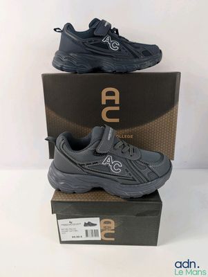 une paire de chaussures pour enfants dans une boîte posée sur une surface blanche