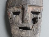 un masque en bois percé d'un trou au milieu