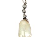 un gros plan d'un pendentif en perle et diamant sur fond blanc