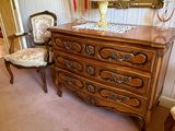 une commode avec un miroir et une chaise dans la pièce