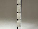 a tall glass and metal floor lamp with a black base