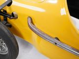 a close up of a yellow race car on display
