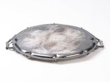 a picture of a silver broochle on a white surface