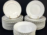 plusieurs assiettes blanches empilées les unes sur les autres sur une surface noire