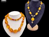 deux colliers et un collier posé sur un présentoir pour mannequin