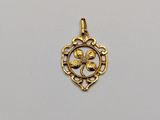 a gold plated pendant with a flower in the center
