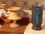 two vases sitting on a table next to each other