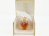 an open box with a perfume bottle inside of it on a white surface