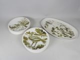 trois assiettes ornées d'oiseaux, posées sur une surface blanche