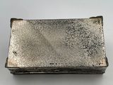 an old silver cigarette case sitting on top of a white table
