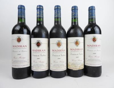 cinq bouteilles de vin rouge alignées les unes à côté des autres