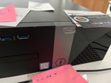 a computer on a table with a pink note on it