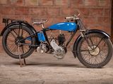 a blue motorcycle that is parked in front of a brick wall