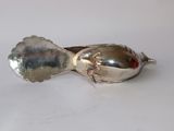 silver spoon and spoon rest on a white surface with a white background