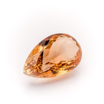 a close up of an orange diamond on a white surface