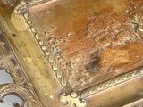 a metal tray with a painting on it on a table