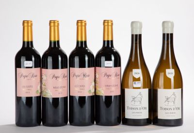 six bottles of wine are lined up in a row on a white surface