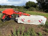 a tractor that is sitting in the grass with a bag on it