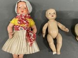 three porcelain dolls of a woman and a baby sitting next to each other