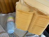 a stack of plastic containers and a plastic bottle on a bed