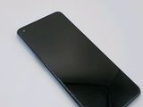 the back of a black cell phone sitting on top of a white table