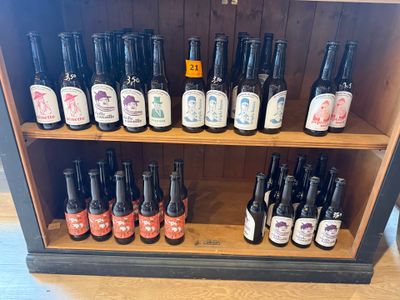 des étagères remplies de bouteilles de différentes sortes de bière, posées sur une étagère en bois