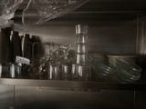 many empty glasses on the shelf in the kitchen