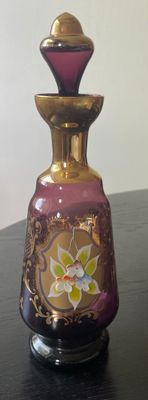 a purple and gold vase sitting on a black table