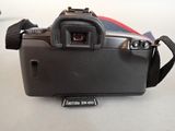 a black camera with a red strap on a white table
