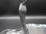 an image of a silver plate with a woman in a dress on it