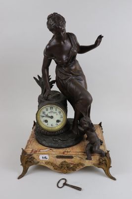 a statue of a woman holding a clock on top of a table