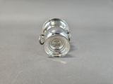 an image of a silver cup with a handle on a table