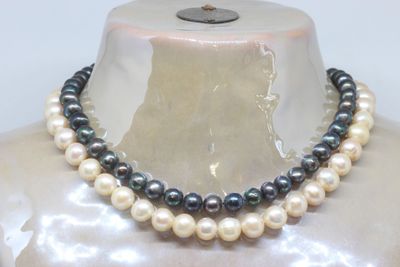 two strands of black and white pearls are on a mannequin