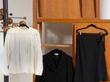 un porte-manteau sur lequel sont accrochées deux vestes et une jupe