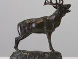 a bronze statue of a stag standing on a rock